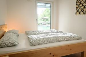 a bed sitting on a wooden bench with a window at Ferienwohnung Bodensee in Meßkirch +16 photos