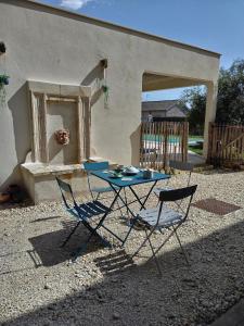 a table and two chairs in front of a house at la caquetoire in Les Églisottes-et-Chalaures