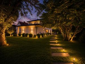 a pathway leading to a house at night with lights at The Royal Residence in Wałbrzych