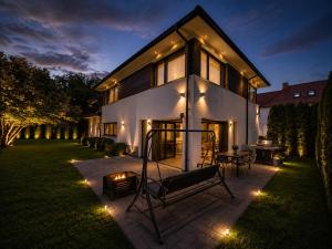 a house with a swing in the yard at night at The Royal Residence in Wałbrzych