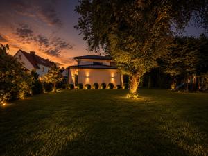 a house with lights in a yard at night at The Royal Residence in Wałbrzych