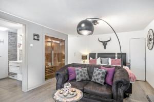 a living room with a leather couch and a table at Eifel-Dream Kalkmulde in Fleringen