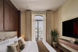 a hotel room with a bed and a large window at Centoria Hotel By Urban B in Ho Chi Minh City