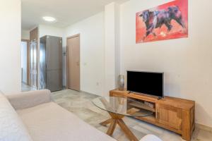 a living room with a tv and a glass table at Sunny Calahonda Park in Sitio de Calahonda