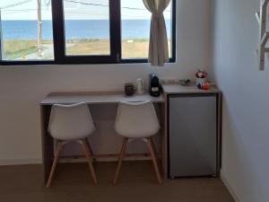 a desk with two chairs in a room with a window at Maracas Sea View Boutiq in Costinesti