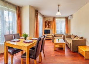 a living room with a table and a couch at Hotel Bojur & Bojurland Apartment Complex in Bansko