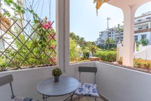 a table and chairs on a balcony with windows at Sunny Calahonda Park in Sitio de Calahonda