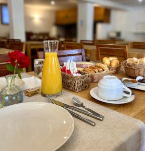 a table with plates of food and a bottle of orange juice at Hôtel Le Chastellan in Valberg
