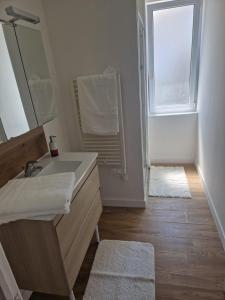 a bathroom with a sink and a mirror and a window at Appartement 2 Ch la Romagne in La Romagne