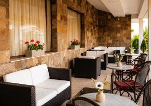 a restaurant with white couches and tables and chairs at Casablanca Hotel - All Inclusive in Obzor