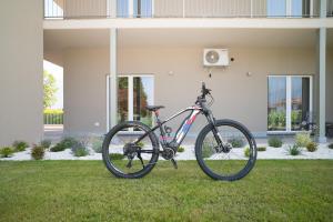 a bike parked in the grass in front of a house at Foresteria Pian di Spagna 2 in Dubino