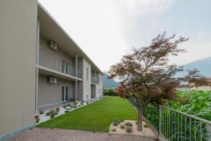 an apartment building with a small tree in the courtyard at Foresteria Pian di Spagna 2 in Dubino