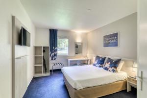 a hotel room with a bed and a desk at ACE Hôtel Rouen Parc des Expositions in Le Petit-Couronne +12 photos