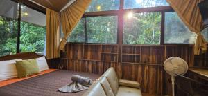 a bedroom with a bed and a fan and windows at Cool Waters Jungle Villas in Uvita +85 photos