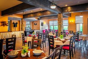 a restaurant with tables and chairs in a room at Hotel Bojur & Bojurland Apartment Complex in Bansko