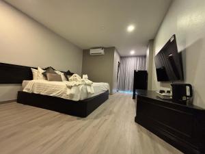 a bedroom with a bed and a television in it at Hotel De Kiang Muang in Chiang Mai