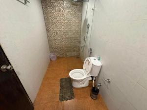 a small bathroom with a toilet in a stall at Tvessa-A Boutiqe Hotel in Mandrem