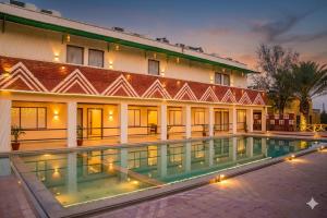 a building with a swimming pool in front of it at Thar Exotica Hotel & Resort Bikaner in Bikaner