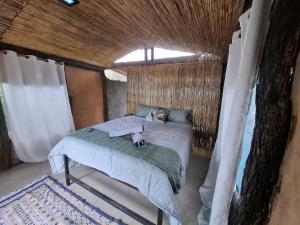a bed in a small room with a window at Hennies HideOut in Kachikau
