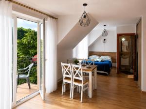 a room with a table and chairs and a bedroom at Pensjonat Bursztyn in Dąbki
