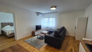 a living room with a couch and a bed at MyPlace apartmani 42,56,70 in Tuzla