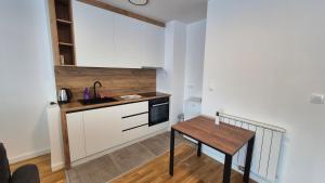 a small kitchen with a table and a sink at MyPlace apartmani 42,56,70 in Tuzla