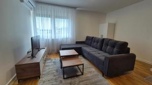 a living room with a couch and a table at MyPlace apartmani 42,56,70 in Tuzla