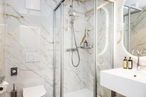 a bathroom with a shower and a toilet and a sink at Hotel Sandwirth in Klagenfurt