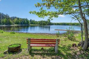 a park bench sitting next to a lake at Lang Lodge cabin in Drummond +34 photos
