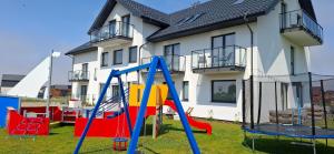 a playground in a yard in front of a house at Bursztynowa Rosa & Wypożyczalnia rowerów elektrycznych in Łeba