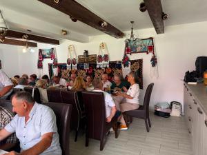 a group of people sitting in a restaurant at Pensiunea Popan in Şieu