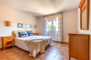 a bedroom with a bed and a window at Son Bou Pool and Sea in Son Bou