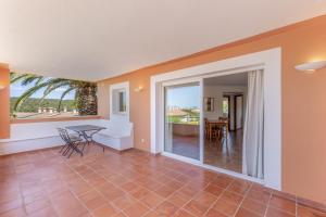 a living room with a table and a dining room at Son Bou Pool and Sea in Son Bou