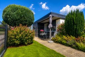 a house with an umbrella in a garden at Schleibungalow Nr15 zw Ostsee und Schlei in Kappeln