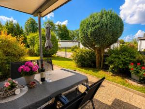 a table with a umbrella and flowers on a patio at Schleibungalow Nr15 zw Ostsee und Schlei in Kappeln