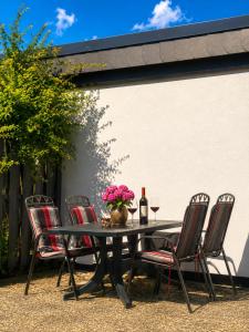 a patio table with chairs and a bottle of wine at Schleibungalow Nr15 zw Ostsee und Schlei in Kappeln