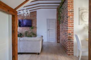 a living room with a couch and a brick wall at Pliusas Residence in Jurbarkas