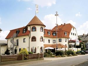 a building with a flag on top of it at Landgasthof Hotel Bechtel in Zella