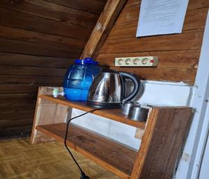 a tea kettle on a wooden shelf in a room at Cozzy Villa Hajeka in Palayangan