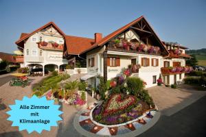 a large house with a flower garden in front of it at Pension Gabriele in Unterlamm