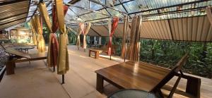 a patio with tables and chairs and a glass roof at Cool Waters Jungle Villas in Uvita
