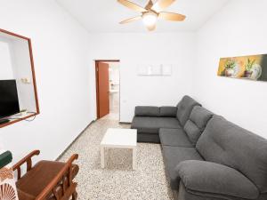 a living room with a gray couch and a tv at Casa de Los Arbolitos in El Palmar