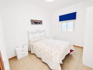 a white bedroom with a bed and a window at Casa de Los Arbolitos in El Palmar