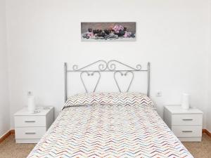 a bedroom with a bed and two white night stands at Casa de Los Arbolitos in El Palmar +10 photos