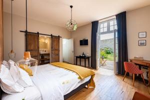 a bedroom with a large bed and a desk at B&B Clerval - Maison d'hôtes et Gîtes in Dragey