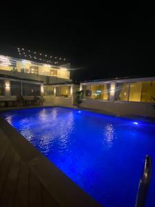 a large swimming pool at night with blue illumination at Cafe Itaewon Pool & Villa in Sampong