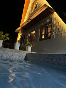 a swimming pool in front of a house at night at Coco Homes Katra in Katra