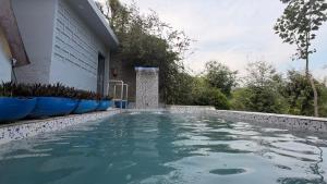 a swimming pool in a backyard with blue chairs at Coco Homes Katra in Katra +17 photos