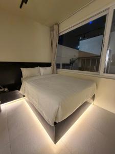 a bedroom with a bed with a window and lights at Cafe Itaewon Pool & Villa in Sampong