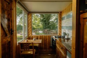 a kitchen with a table and a window in a house at The Cosy Nest Hut in Keddington